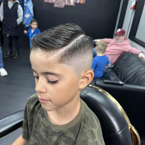 Kids comb-over with a hard part and smooth skin fade