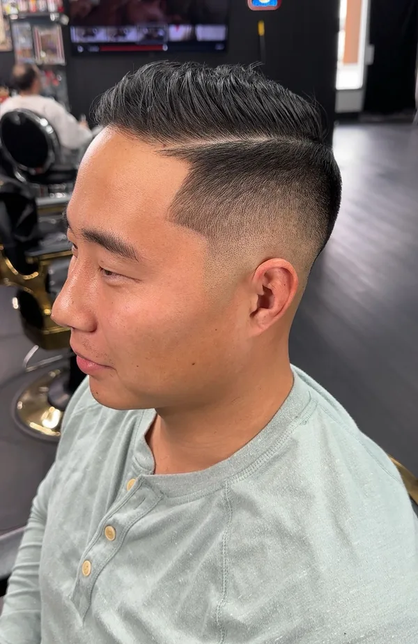 Comb-over pompadour with a hard part and high fade by Aldo Barragan